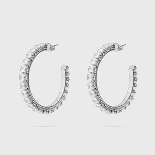 Pair of silver hoop earrings with clear gemstones on a light gray background