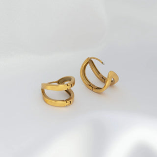 Pair of gold hoop earrings on a light gray background