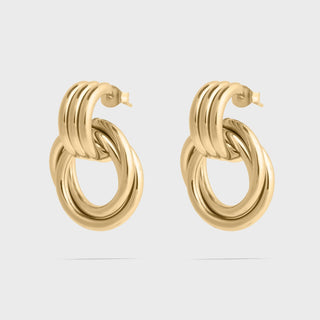 Gold hoop earrings on a light gray background