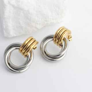 Pair of gold and silver hoop earrings on a white background