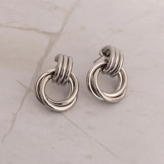 Pair of silver hoop earrings on a light marble background