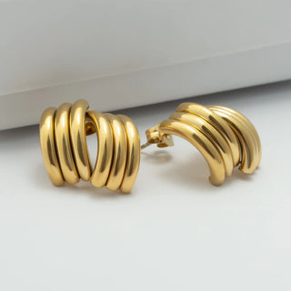 Pair of gold hoop earrings on a light gray background