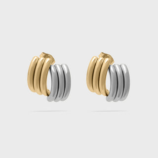 Pair of gold and silver hoop earrings on a light gray background