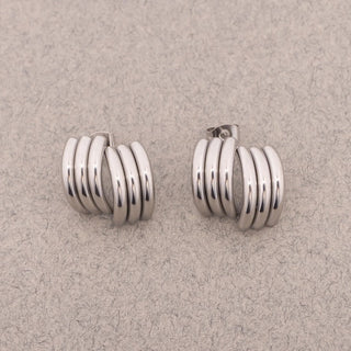 Pair of silver hoop earrings on a beige background