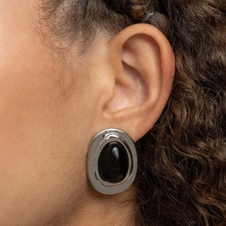 Close-up of an ear wearing a black and silver Black Enamel Stud Earrings.