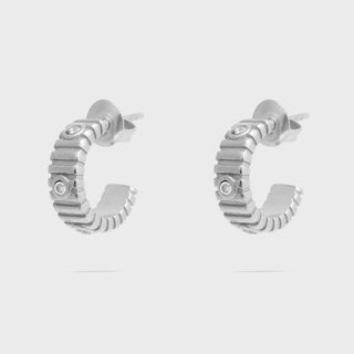 Pair of silver hoop earrings with small diamonds on a light gray background