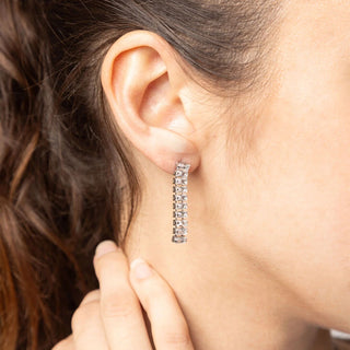 Close-up of a person wearing a diamond earring with a blurred background