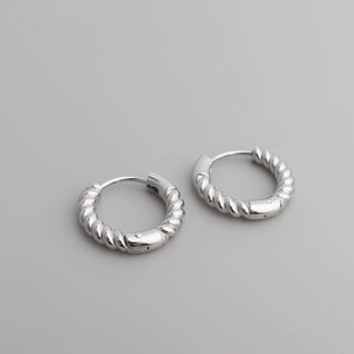 Pair of silver hoop earrings on a gray background