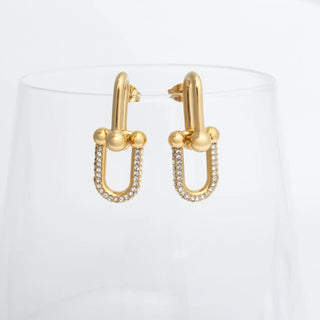 Gold hoop earrings with small diamonds on a white background