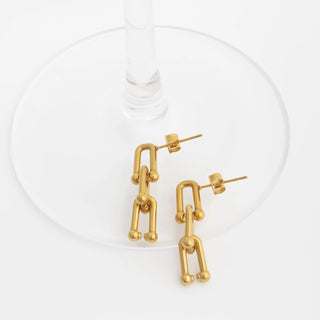 Gold abstract earrings on a white background