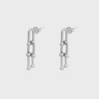 Pair of silver chain-link earrings on a light gray background