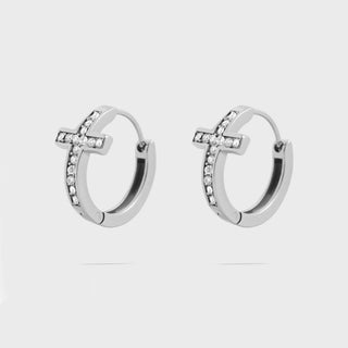 Silver cross hoop earrings with small cz stones on a light gray background