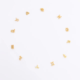 Gold zodiac earrings in a circle on a white background