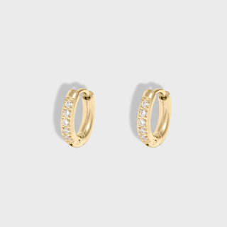 Gold hoop earrings with embedded stones on a light gray background