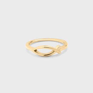 Gold ring with a unique design on a light gray background