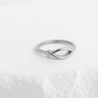Silver ring with a unique design on a light gray background