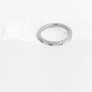 Silver ring with engraved text on a white background