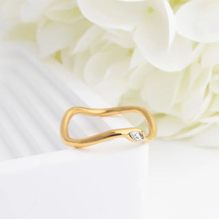 Gold ring with a diamond on a white floral background