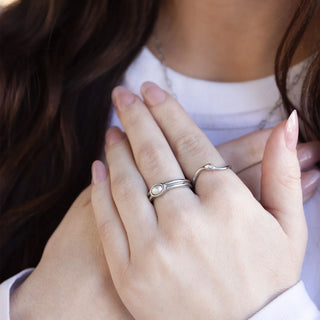 Close-up of hands with silver rings on a blurred background
