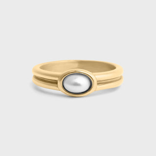 Gold ring with a central pearl on a light gray background