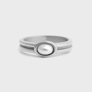 Silver ring with a central pearl on a light gray background