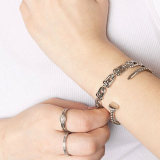 Close-up of a wrist wearing a silver chain bracelet with a white background