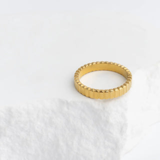 Gold ring with a textured band on a white background
