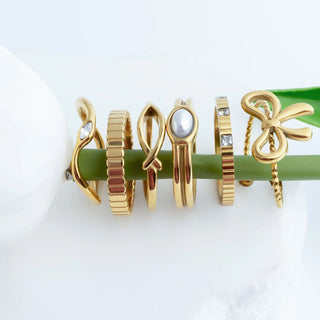 Set of gold rings with various designs on a white background