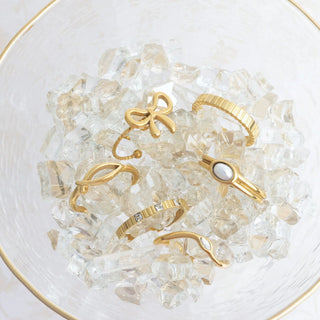 Gold rings on a bed of clear crystals in a glass bowl