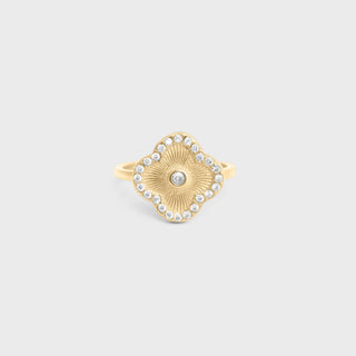 Gold ring with gemstones on a light gray background