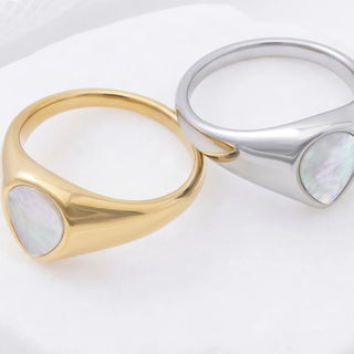 Gold and silver rings with mother-of-pearl inlays on a white background
