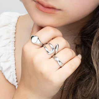 Close-up of a hand wearing three silver rings