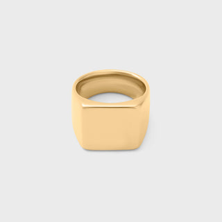 Gold square signet ring on a light gray background