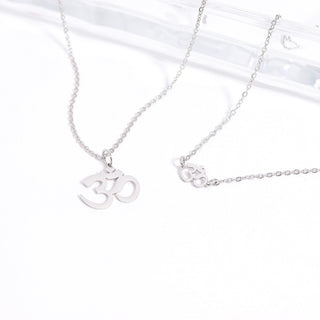 Silver necklace with Om symbol pendant on a white background