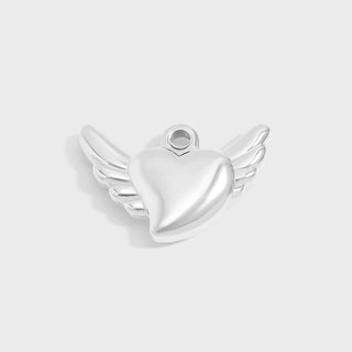 Silver heart-shaped pendant with wings on a light gray background