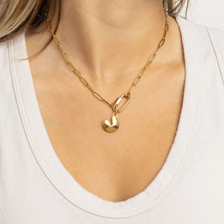 Gold chain necklace with a fortune cookie pendant worn by a person on a white background