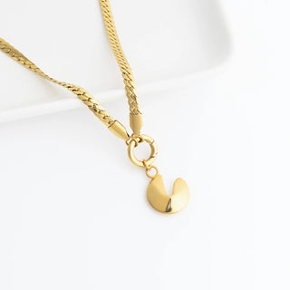 Gold necklace with a fortune cookie pendant on a white background
