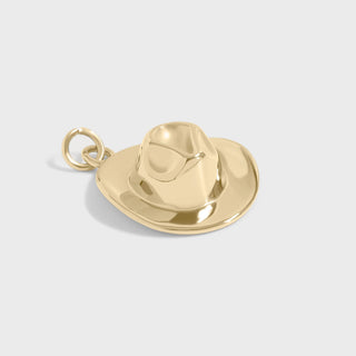 Gold cowboy hat and boot charm on a light gray background
