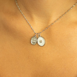Necklace with two round pendants  including the shell design charm on a person's neck 