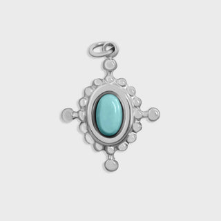 Silver compass pendant with a turquoise stone on a light gray background