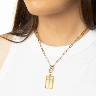 Gold chain necklace with a cross pendant on a mannequin