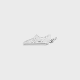 Silver shoe-shaped pendant with Adidas logo on a light gray background