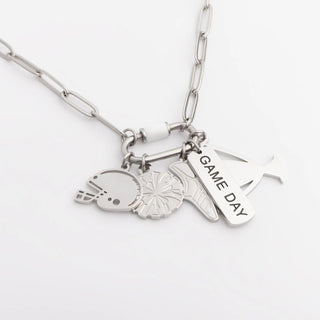 Silver necklace with various charms on a white background