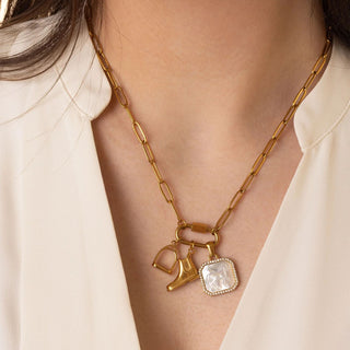 Gold necklace with equestrian charms worn by a person