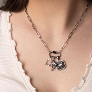 Silver necklace with horse-themed equestrian charms worn by a person