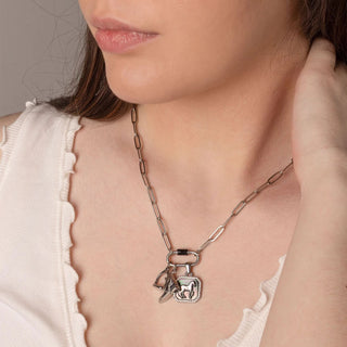 Close-up of a woman wearing a silver necklace with equestrian charms.