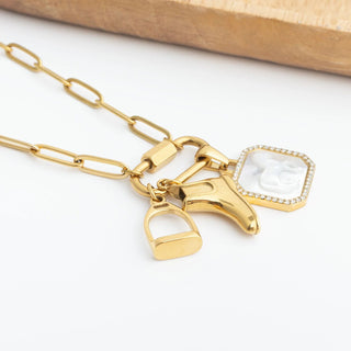 Gold equestrian charms on a white background