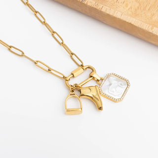 Gold necklace with equestrian and crystal pendants on a white background