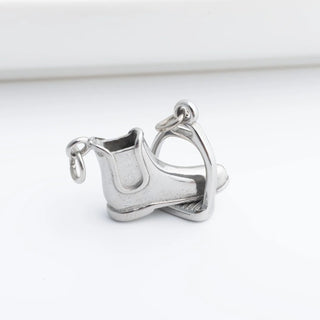 Silver boot and stirrup charm on a white background