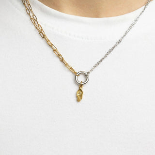 Gold and silver chain necklace with a hand-shaped pendant on a white background